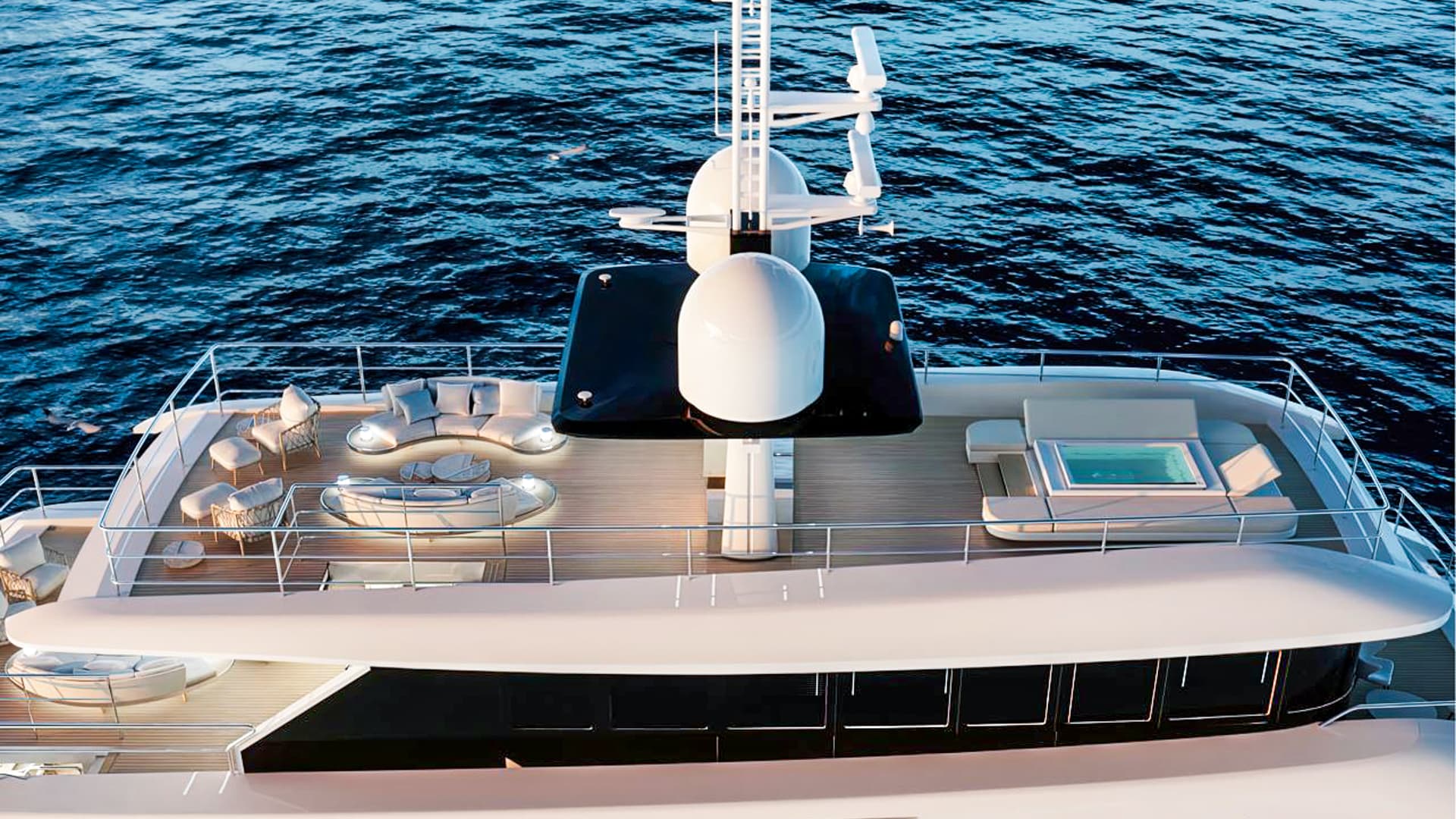 Luxury yacht sun deck with outdoor seating and small pool over dark blue ocean water.