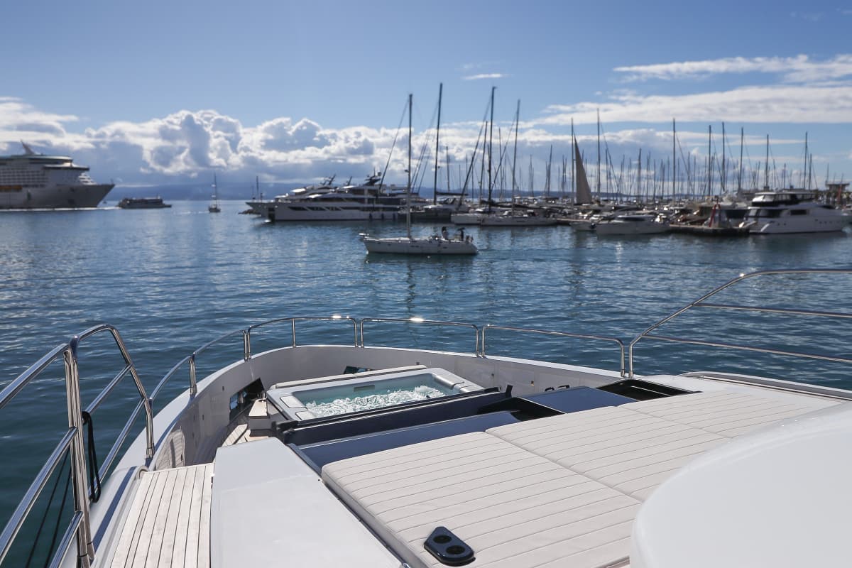 Foredeck jacuzzi and sunpads on a yacht overlooking a busy harbor with many boats.
