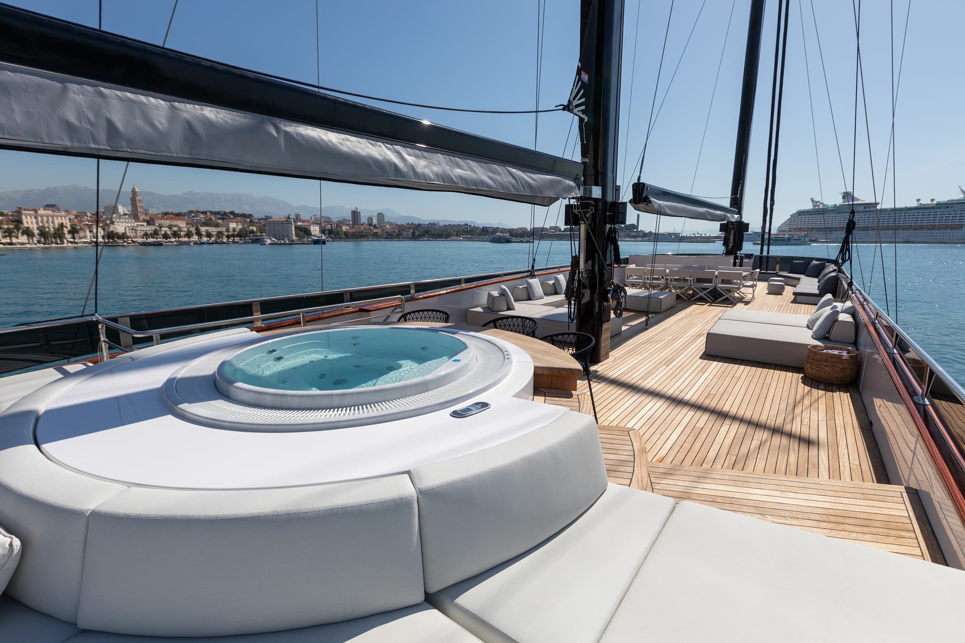 Yacht deck with hot tub and seating overlooking Split, Croatia coastline and mountains