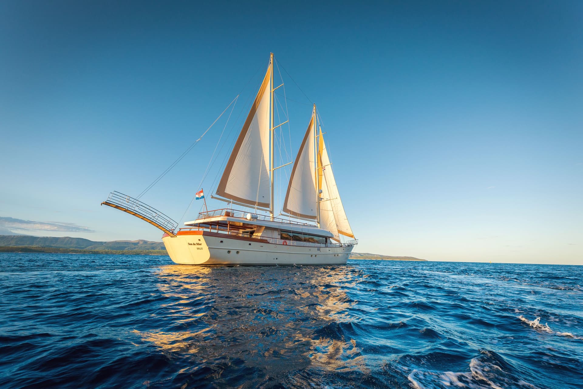 Motor sailer "Son de Mar" from Split sailing on deep blue Adriatic Sea near coastline.