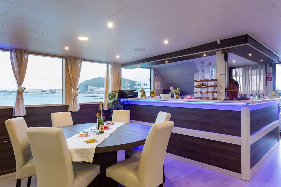 Dining area with bar and sea view, possibly on a boat or cruise ship