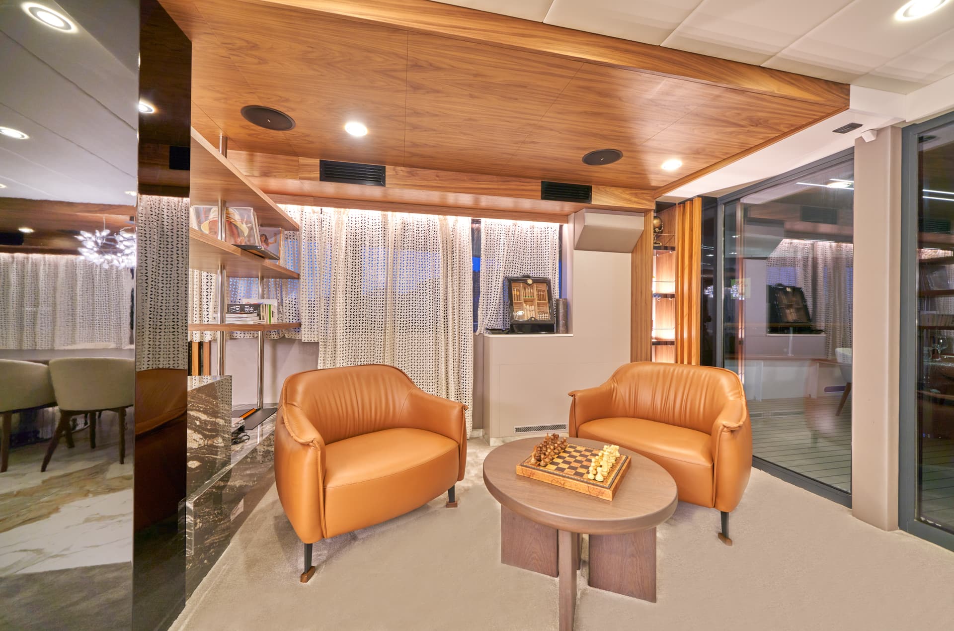 Luxurious lounge area with leather armchairs, wooden ceiling, and chessboard on coffee table.