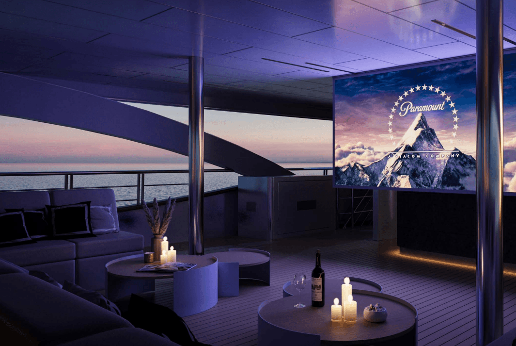 Outdoor cinema screening Paramount logo on a yacht deck at sunset over the sea