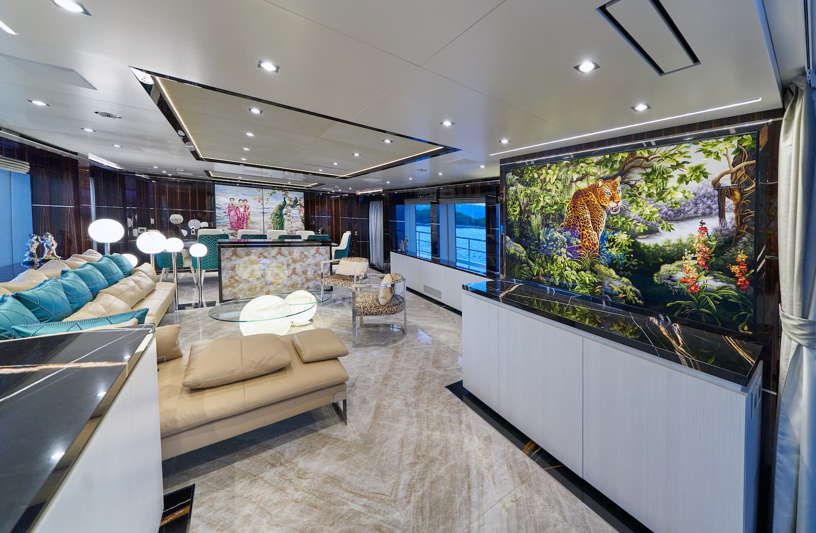 Luxurious yacht interior lounge with marble floors, leopard art, and view of the water.