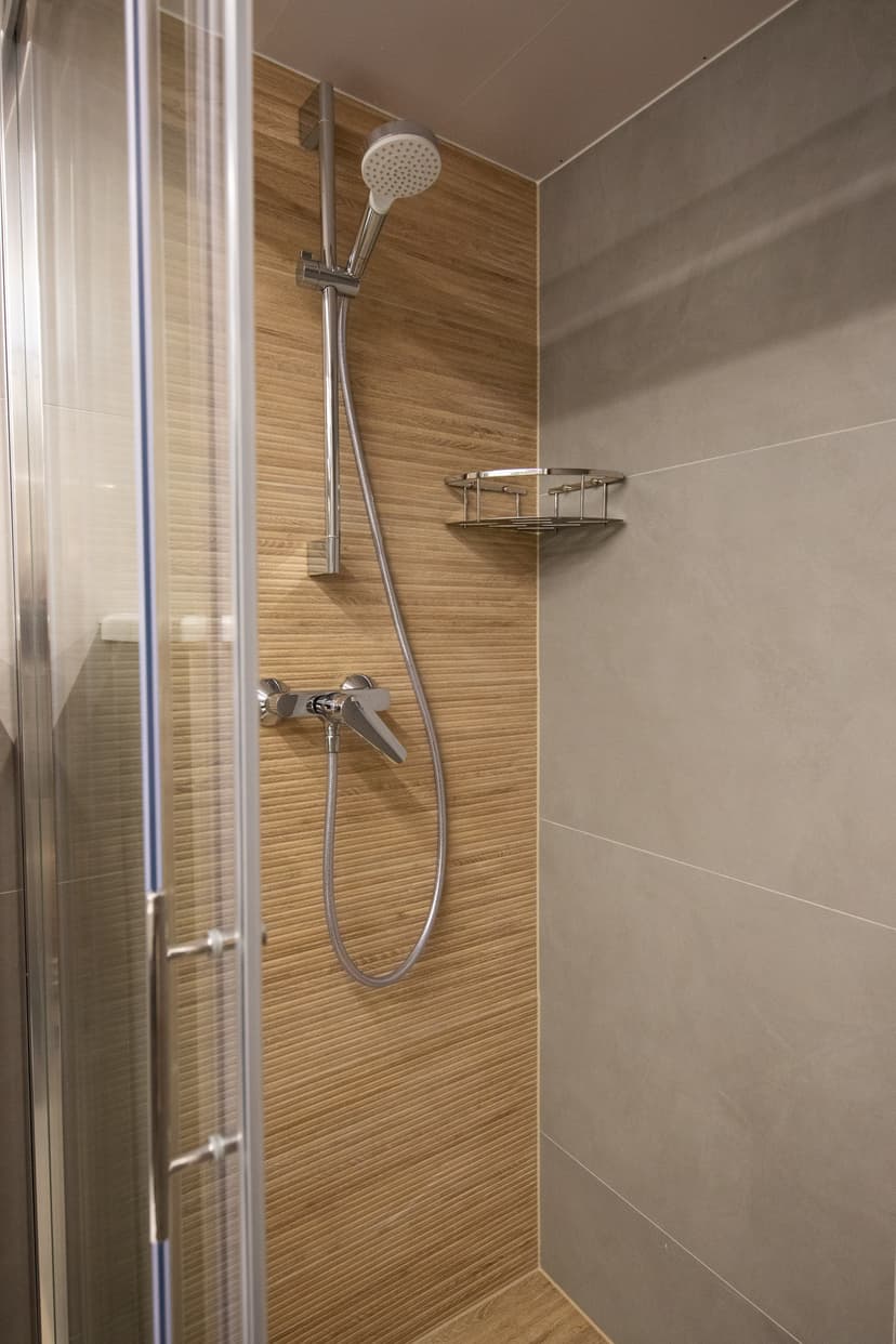 Modern shower stall with wood-grain tiles and chrome fixtures