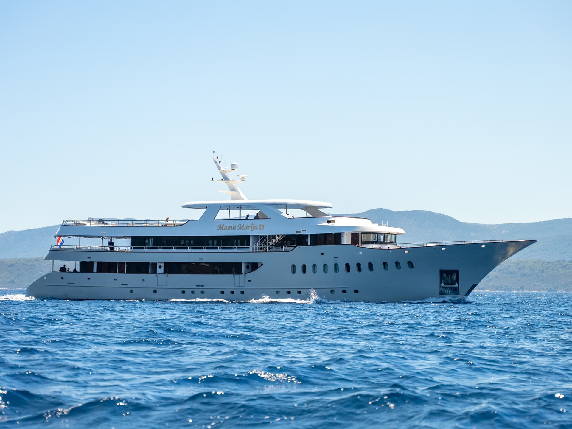 Mama Marija II yacht sailing on blue coastal waters with distant hills