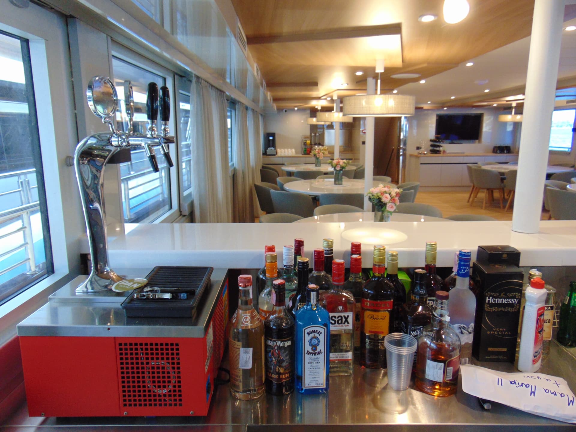 Bar counter with liquor bottles and draft beer tap inside modern lounge