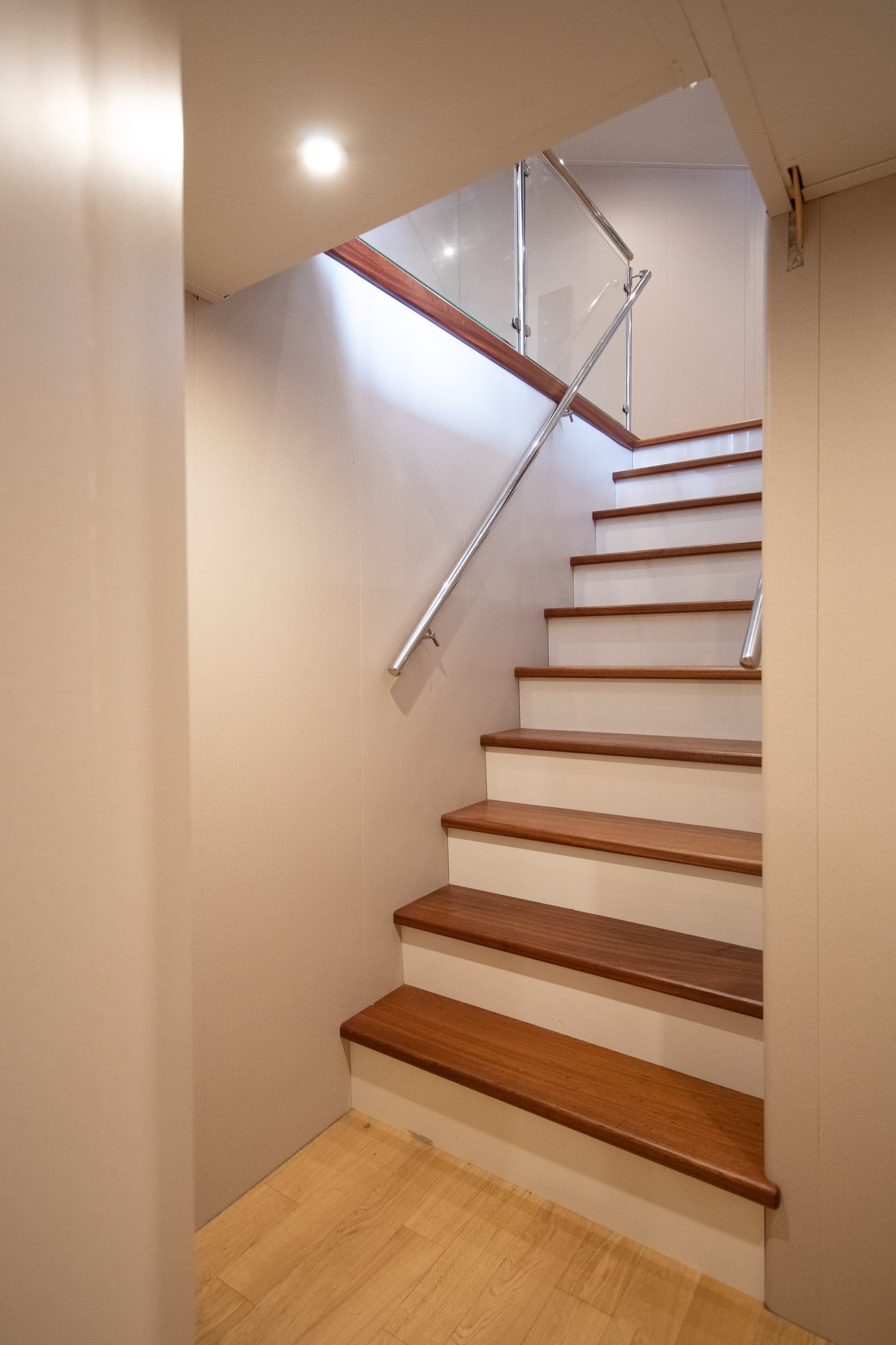 Modern staircase with wooden treads and glass railing