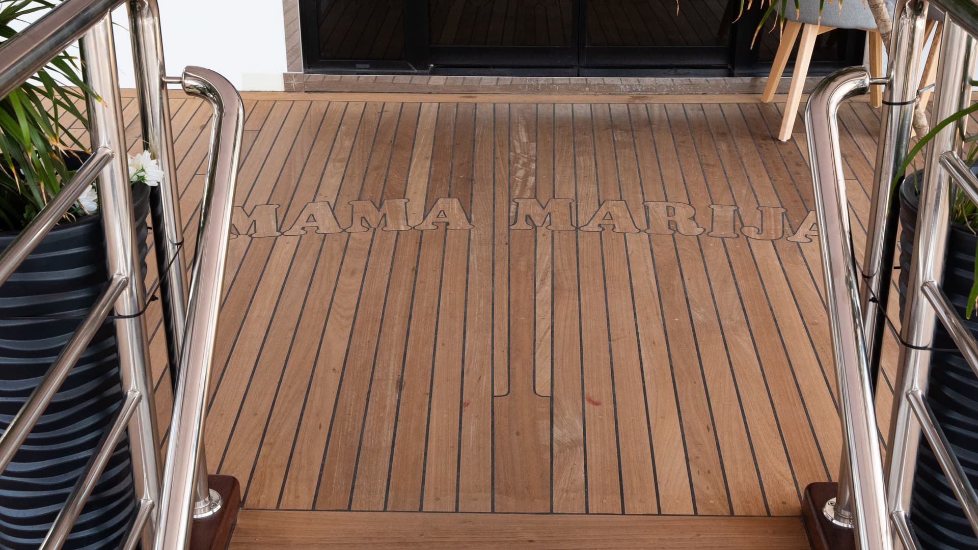 Wooden deck with Mama Marija text inscription and stainless steel handrails