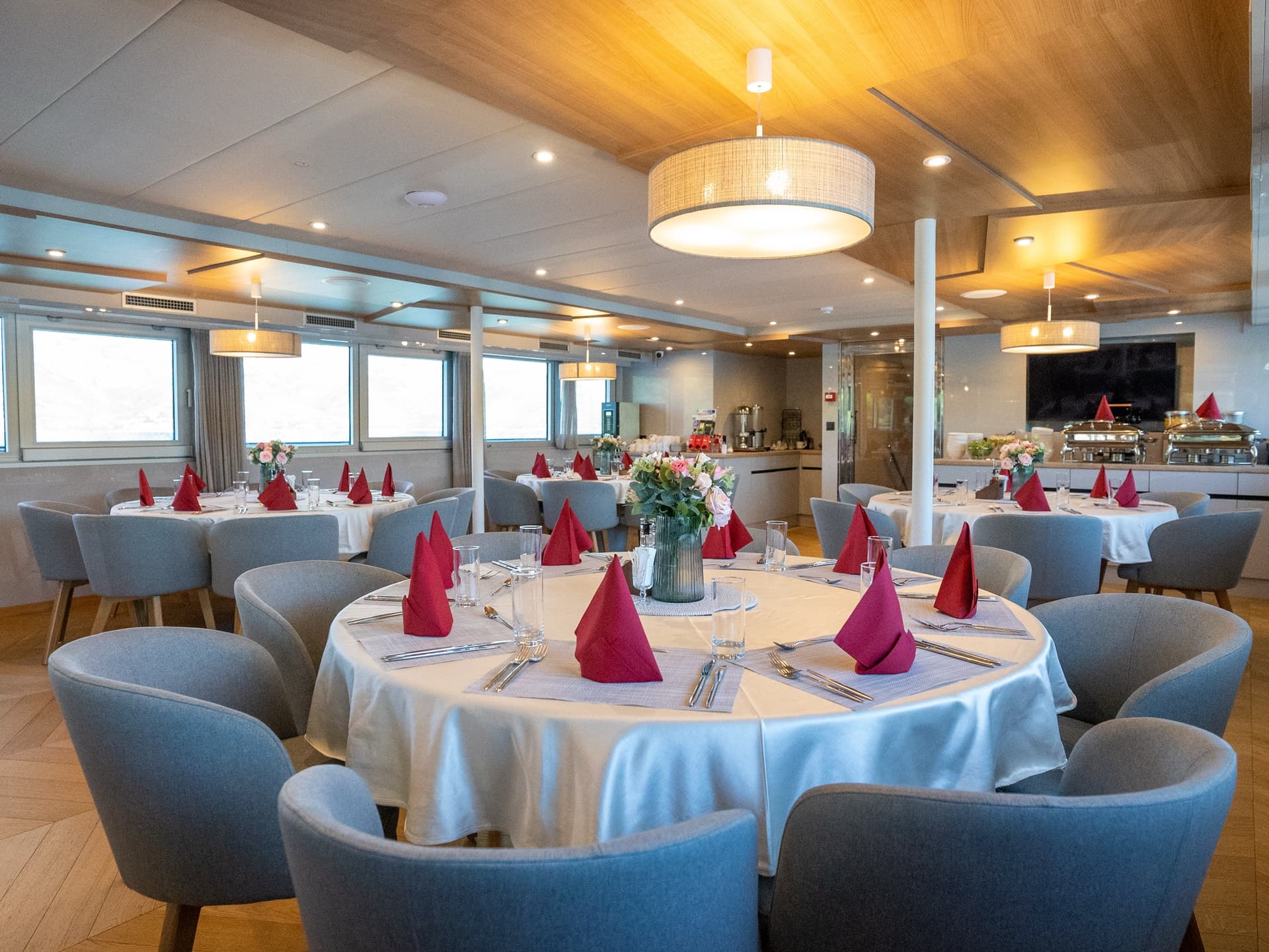 Restaurant dining room with round tables and gray armchairs