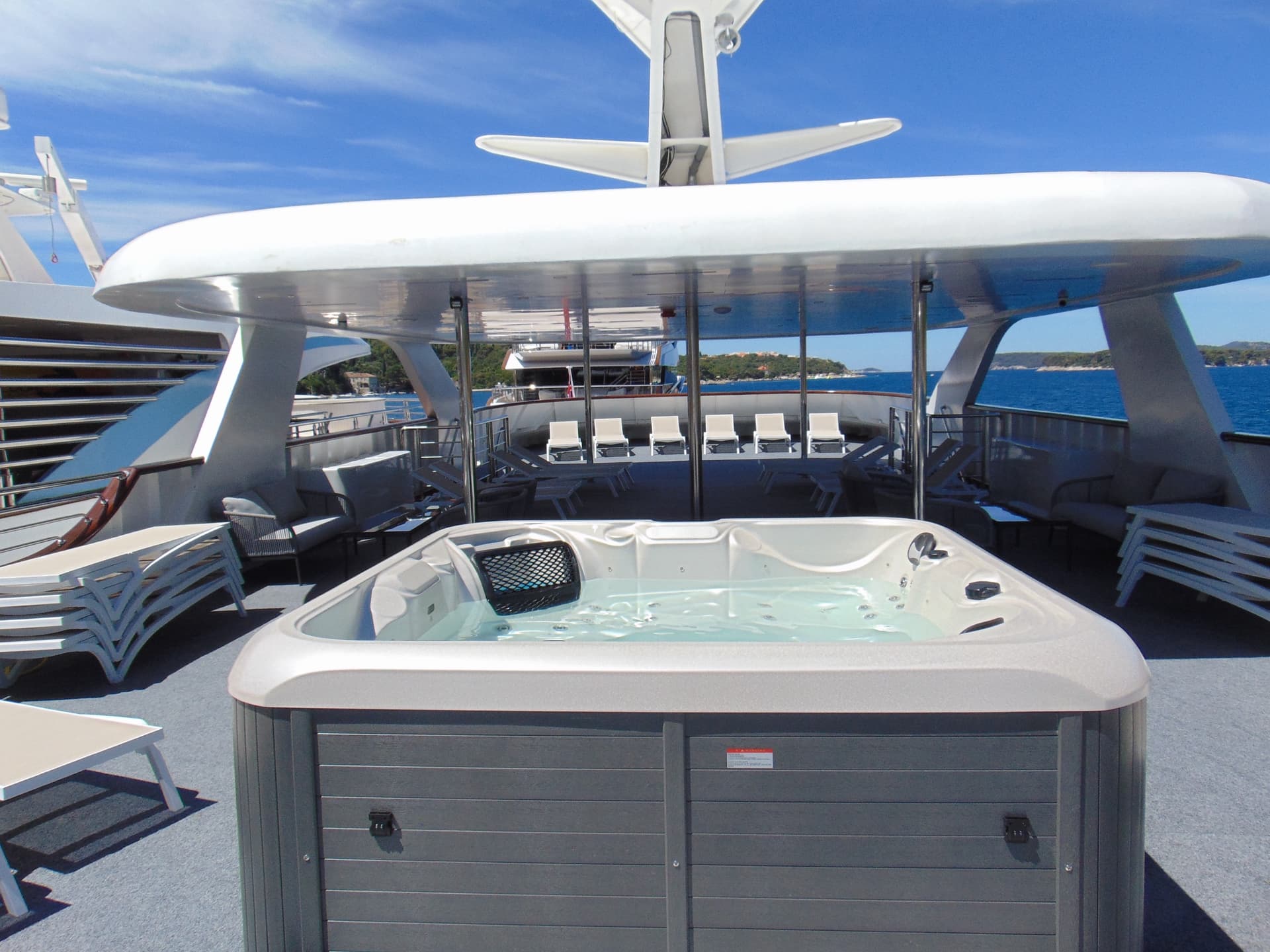 Hot tub on sunny deck of yacht with ocean view