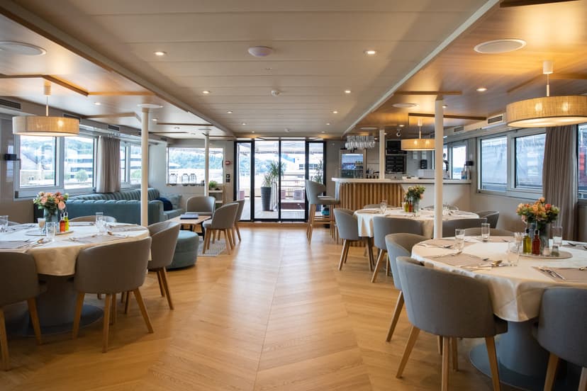 Modern indoor restaurant and lounge area with tables, chairs, and bar counter