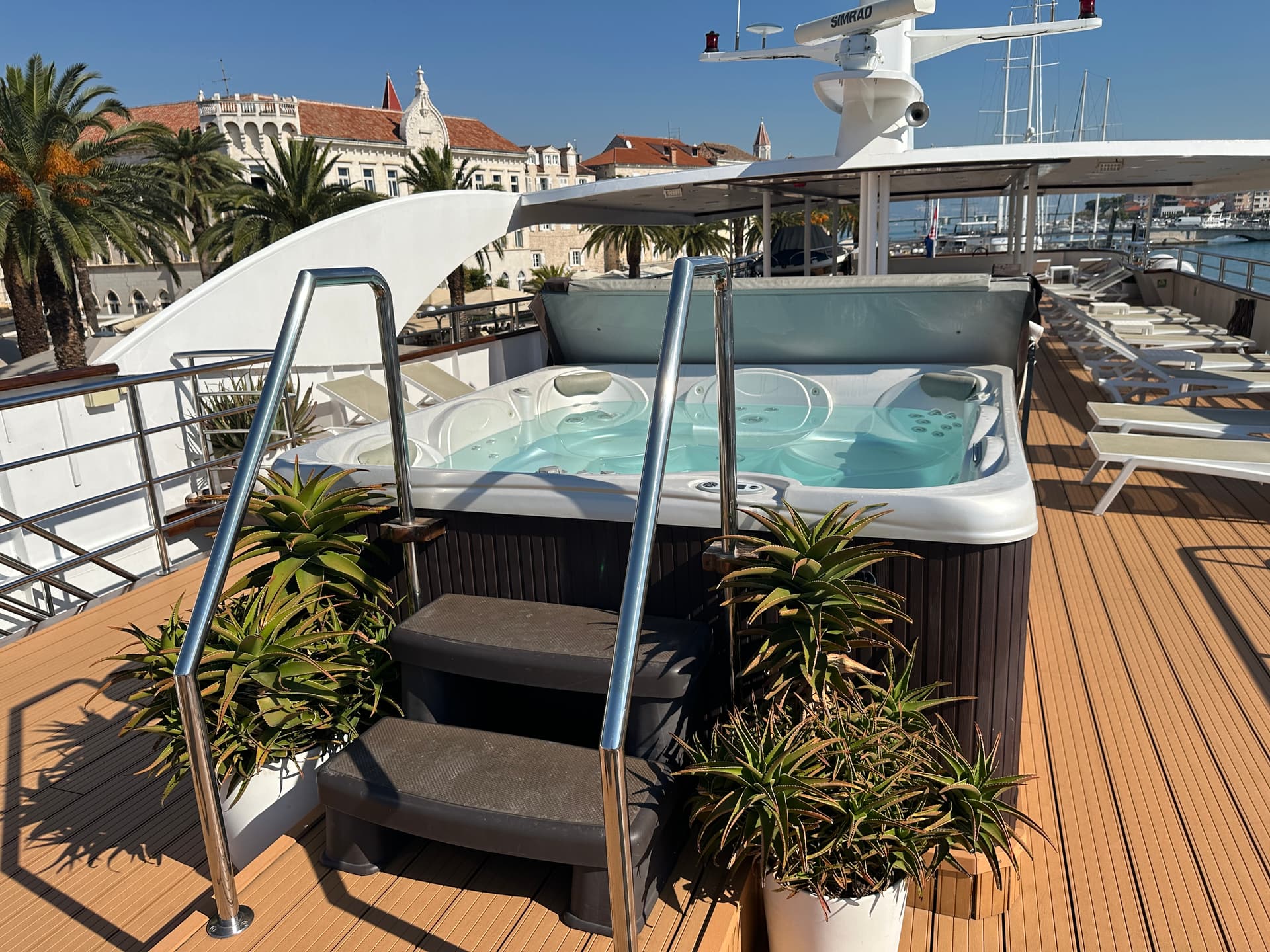 Hot tub on the sun deck of a luxury yacht with coastal town views