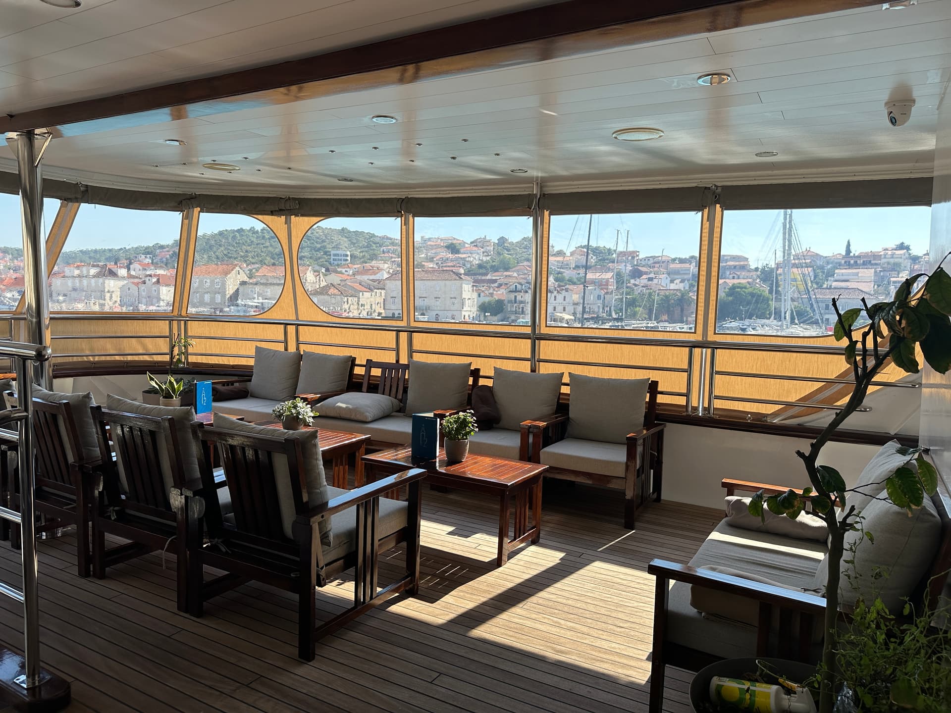 Lobby bar and restaurant seating area on yacht with view of coastal town