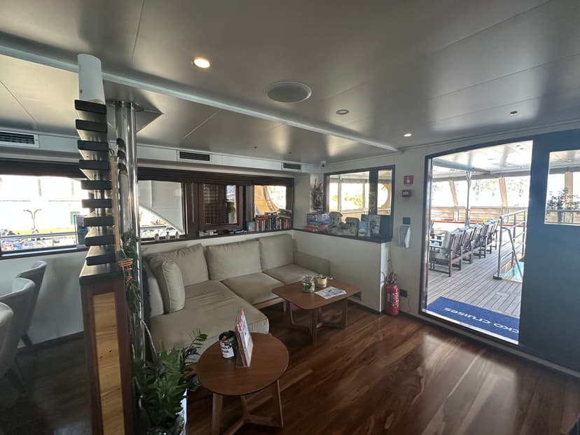 Lounge area with beige sectional sofa, wooden coffee tables, and view of outdoor deck