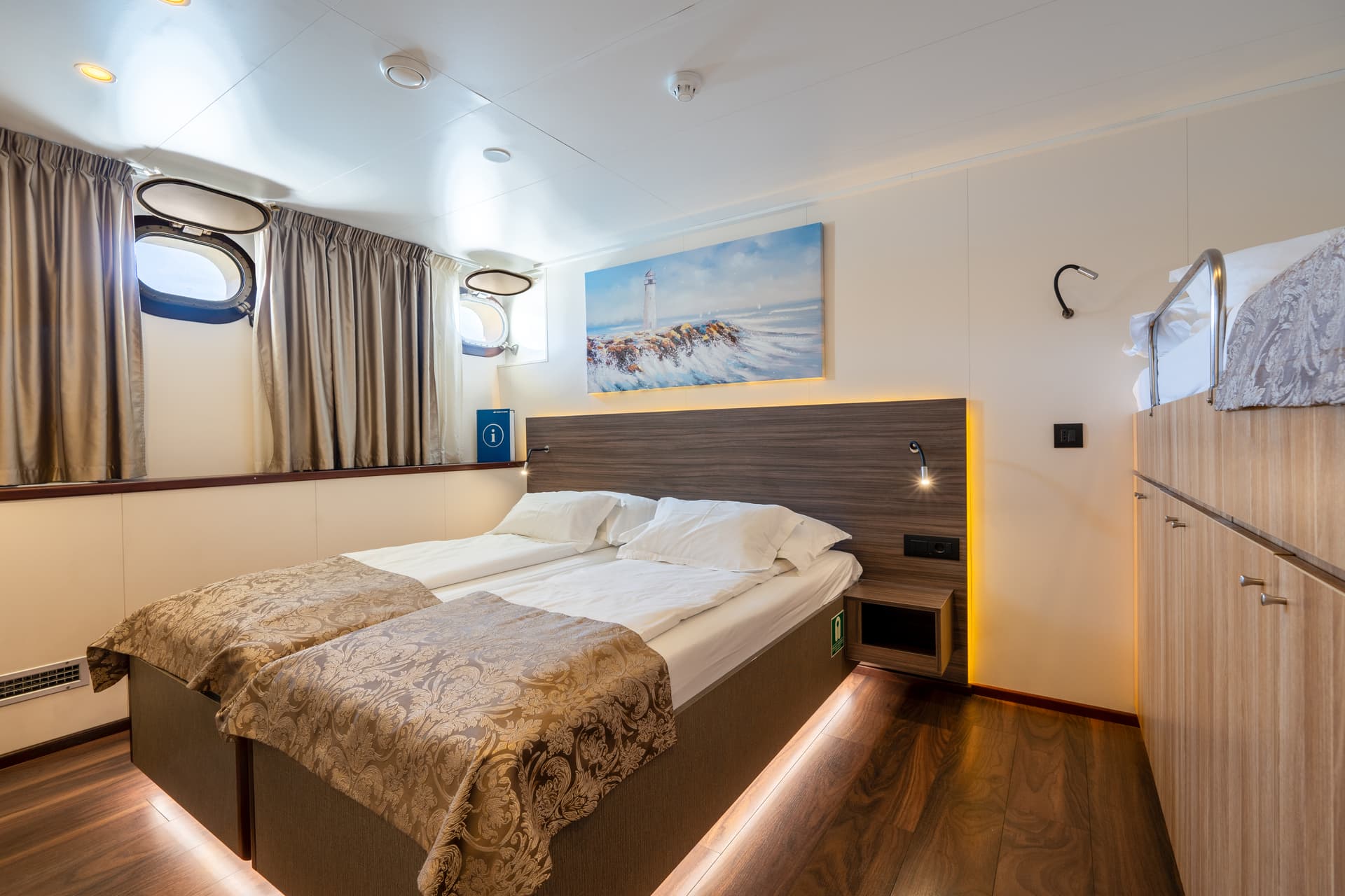 Standard cruise ship cabin interior with twin beds and portholes