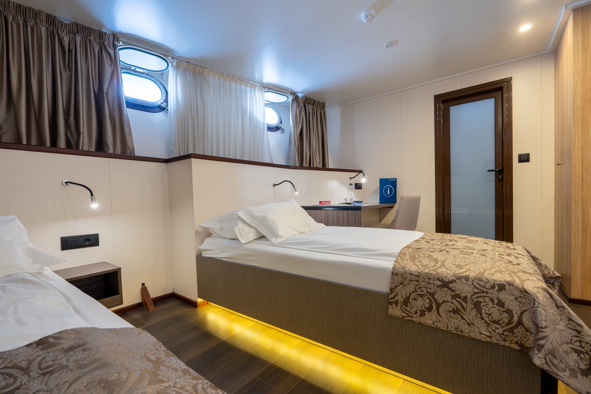 Standard deck cabin with two twin beds and portholes on a ship