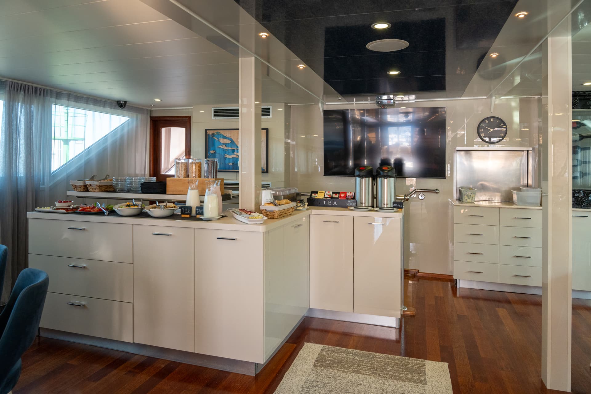 Modern galley kitchen on a boat with breakfast buffet counter and stainless steel appliances