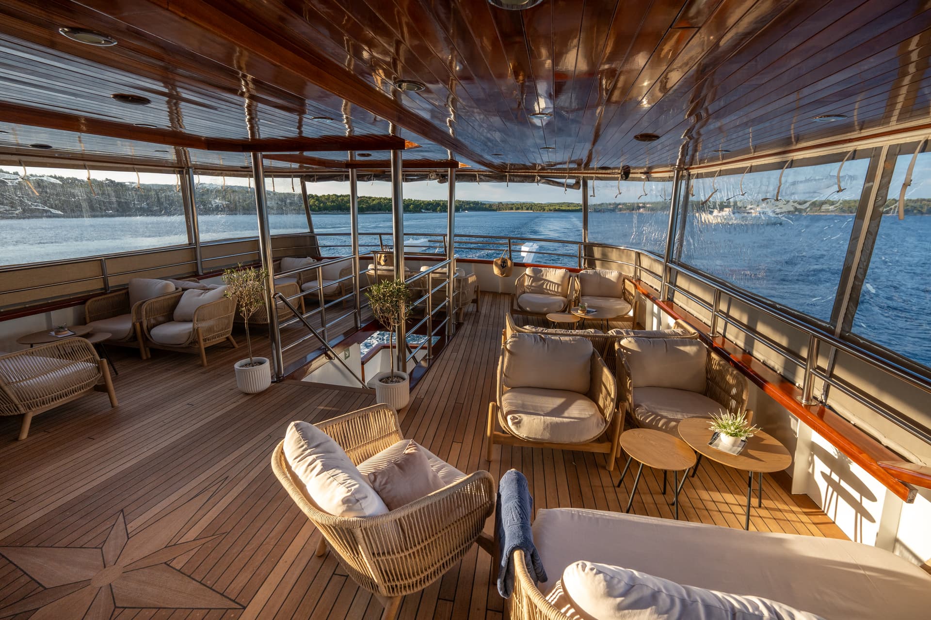 Luxury yacht deck seating area with wooden flooring and ocean view