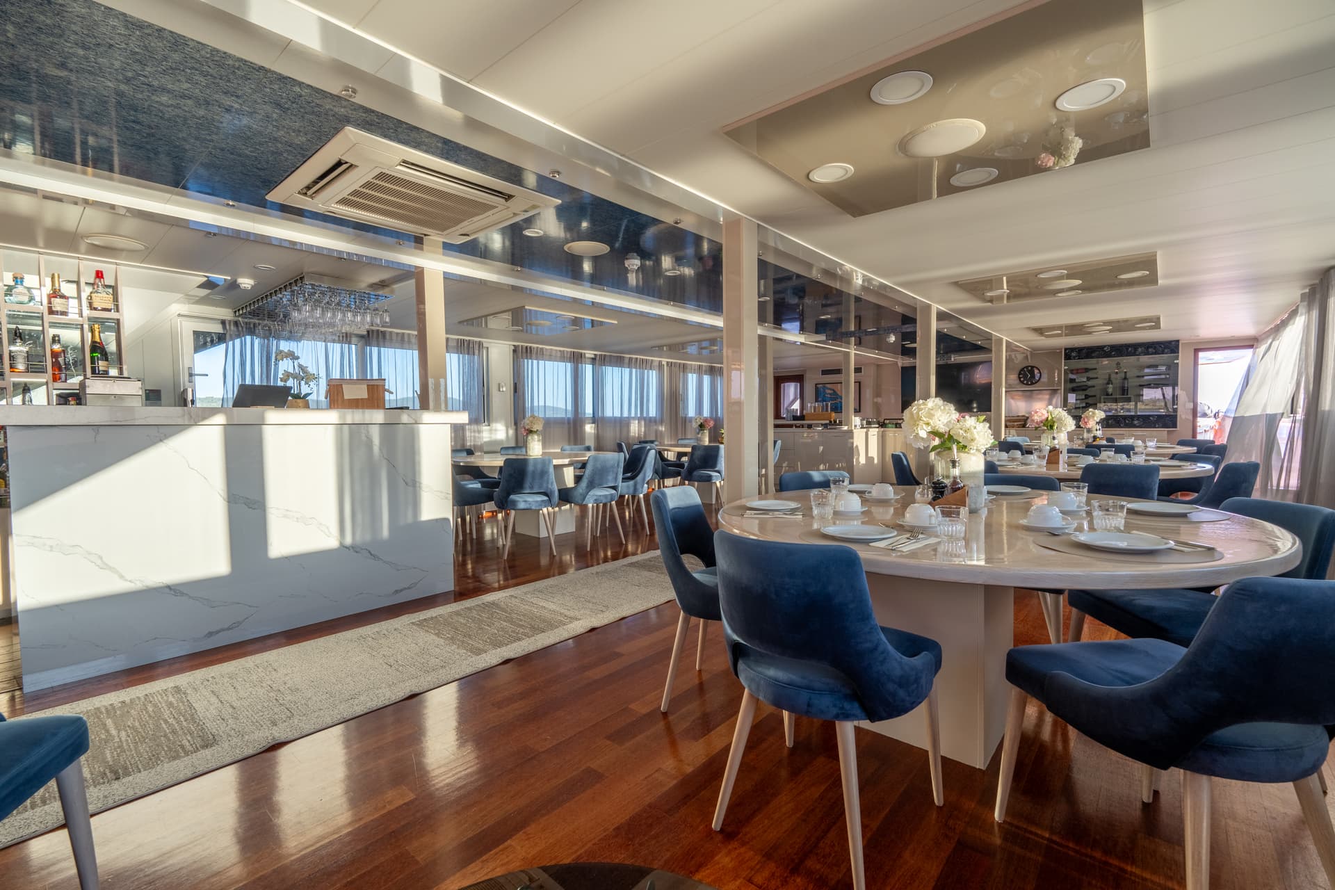 Luxury yacht dining room with blue chairs and bar counter