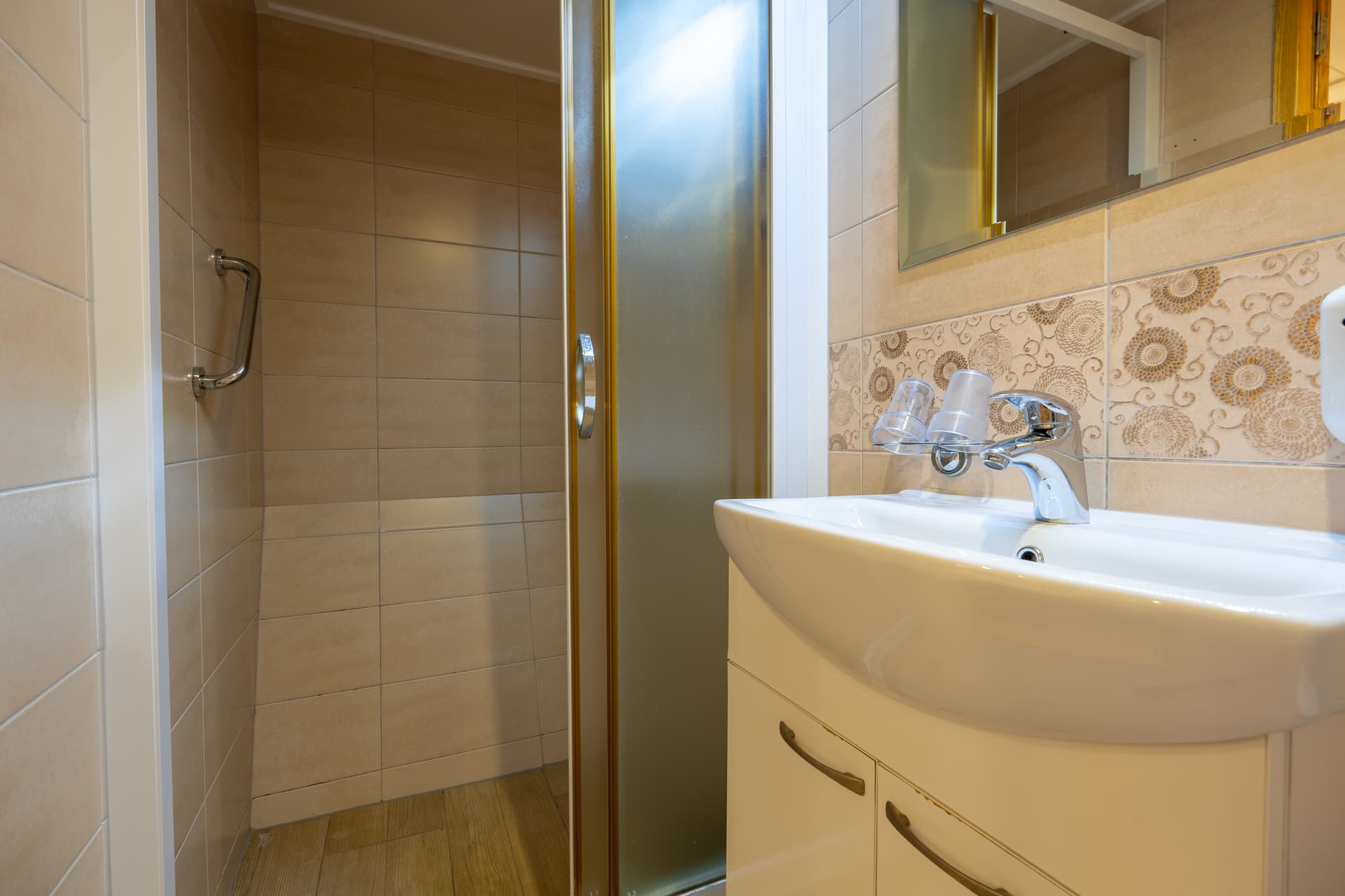 Bathroom sink and vanity with tiled shower stall