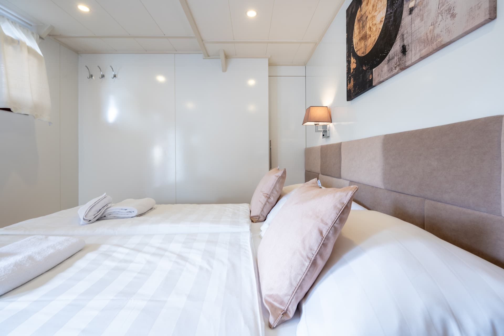 Modern hotel bedroom with white linens and padded headboard