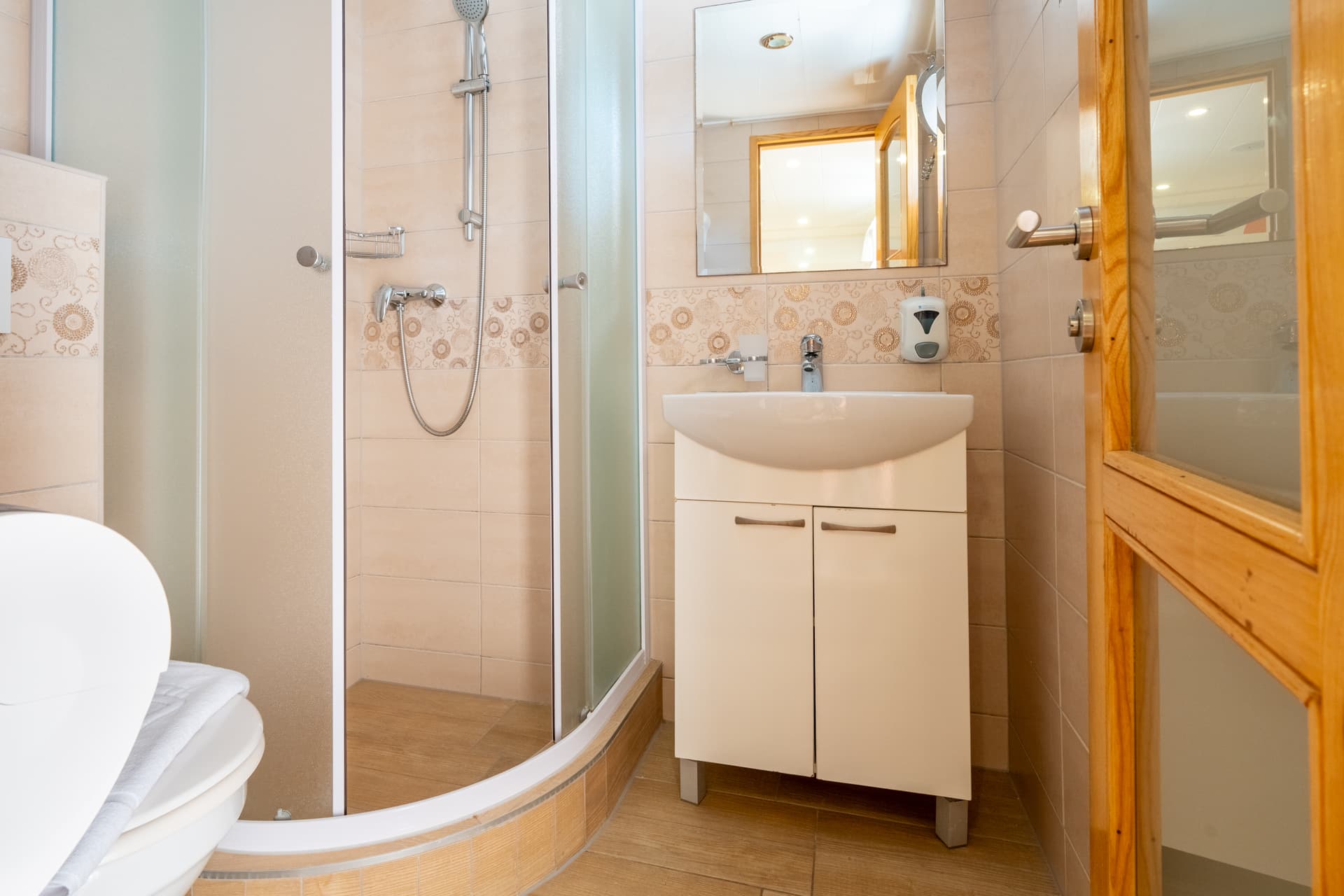 Bathroom interior with glass shower enclosure, vanity sink, and tiled walls