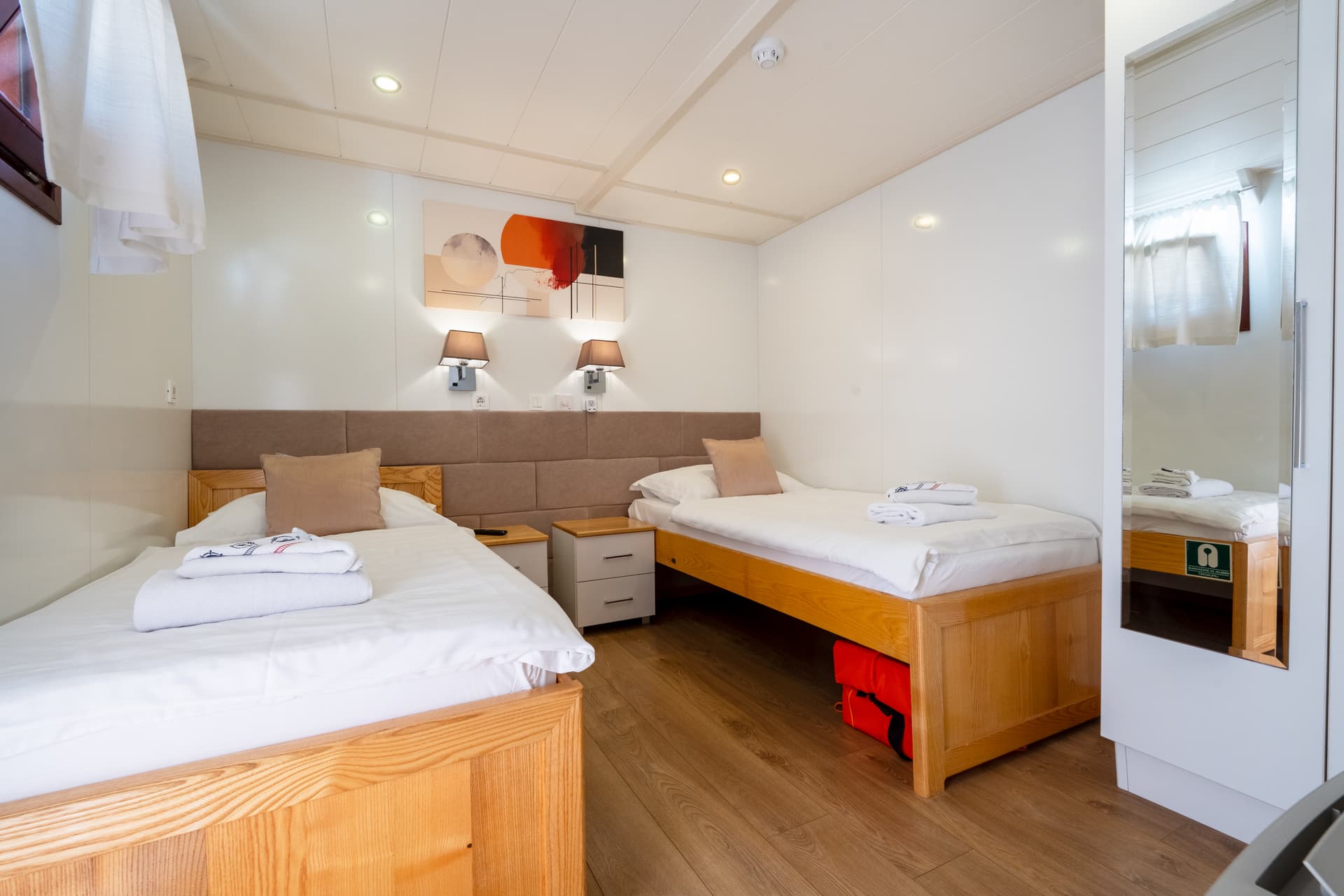 Hotel room with two twin beds, wooden frames, and white linens
