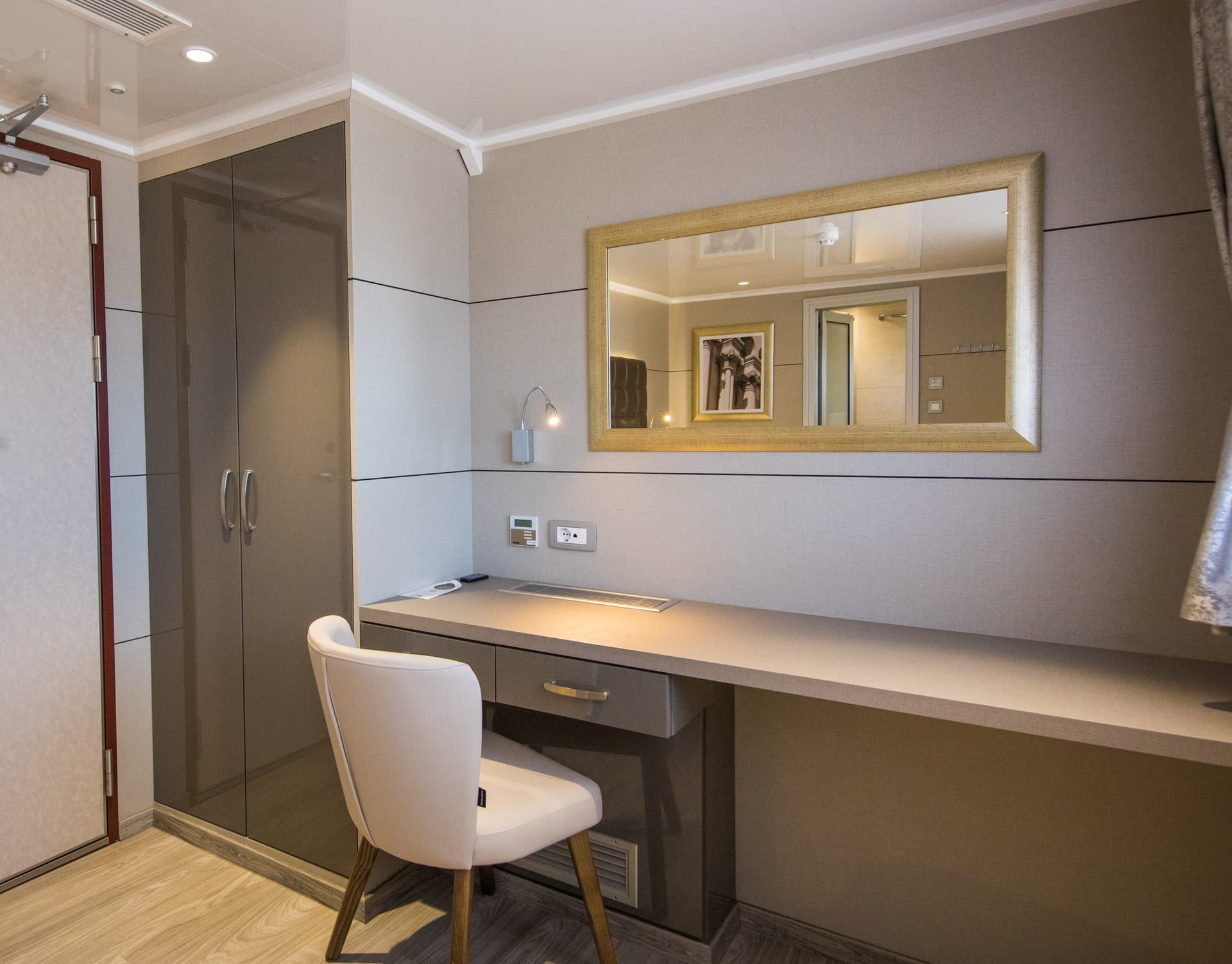 Cabin interior with desk, chair, mirror, and wardrobe on main deck