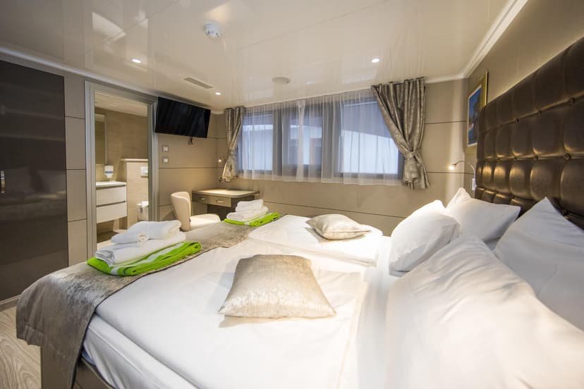 Modern cruise ship cabin bedroom with twin beds and en-suite bathroom