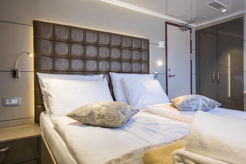 Standard cabin bedroom with double bed and tufted headboard