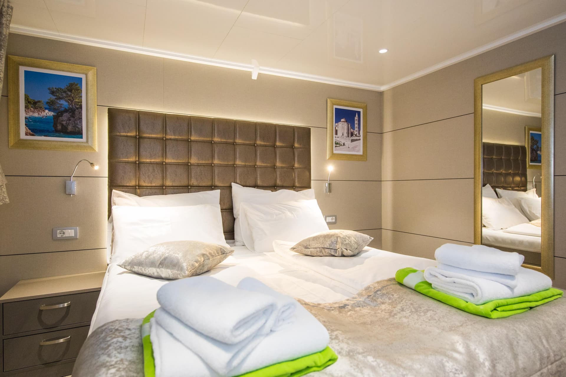 Standard cabin bedroom with double bed, white linens, and folded towels