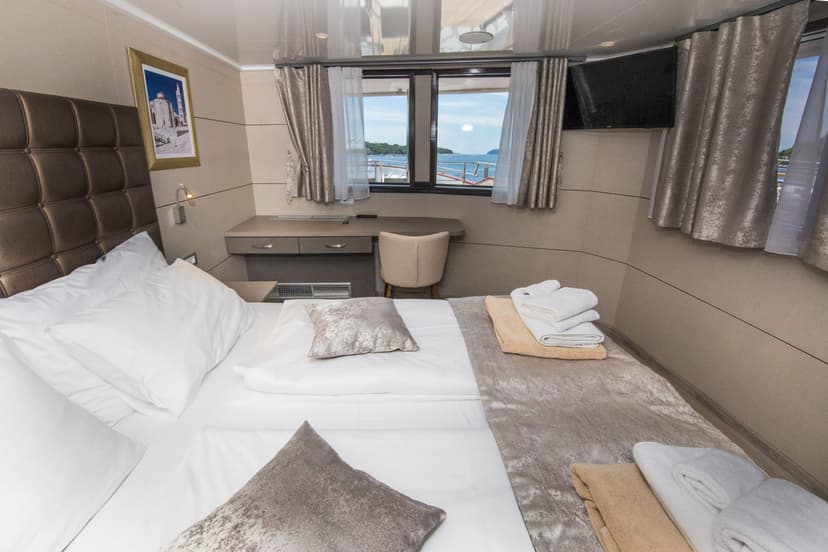 VIP cabin interior on boat with bed, desk, and window overlooking sea
