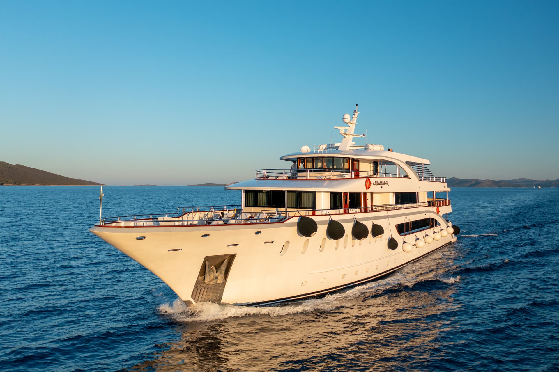 Luxury cruise yacht sailing on calm blue sea under clear sky