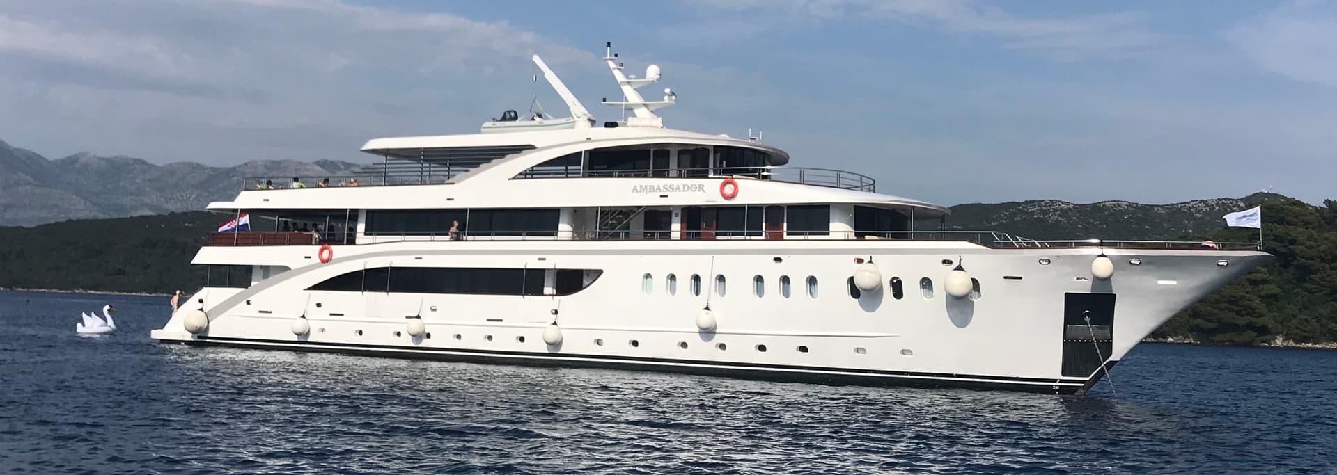Large white Ambassador yacht on calm sea water