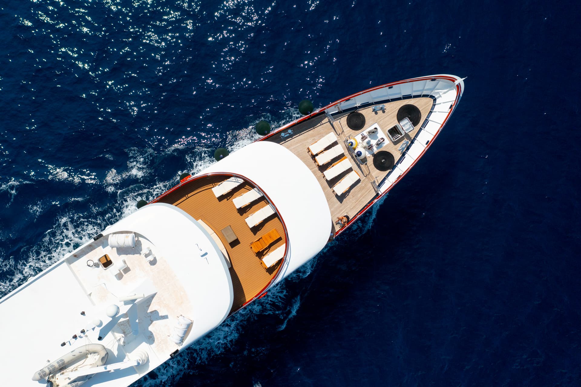 Aerial view of a white yacht cruising on deep blue sea water