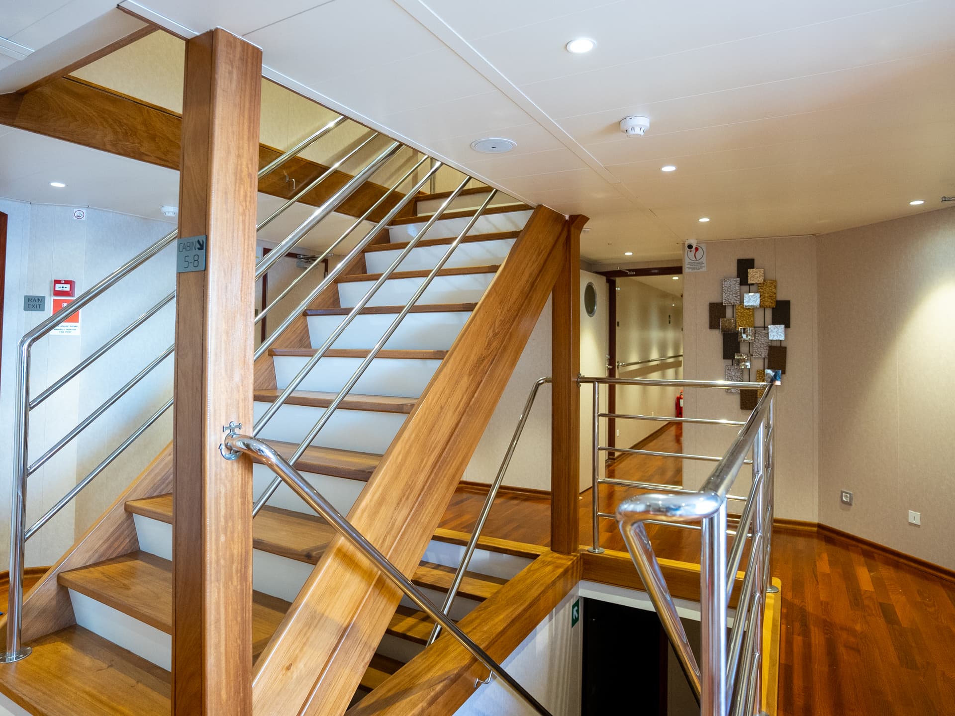 Modern wooden staircase with metal handrails inside ship interior