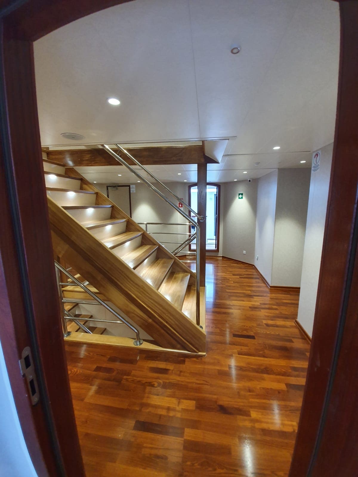 Wooden staircase with metal handrails inside interior hallway