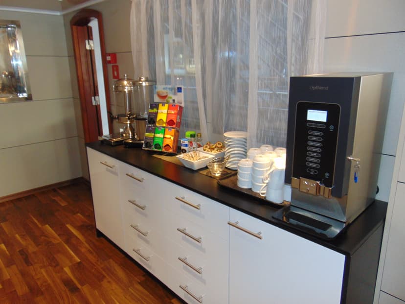 Coffee and tea station on counter in restaurant with beverage dispenser and cups