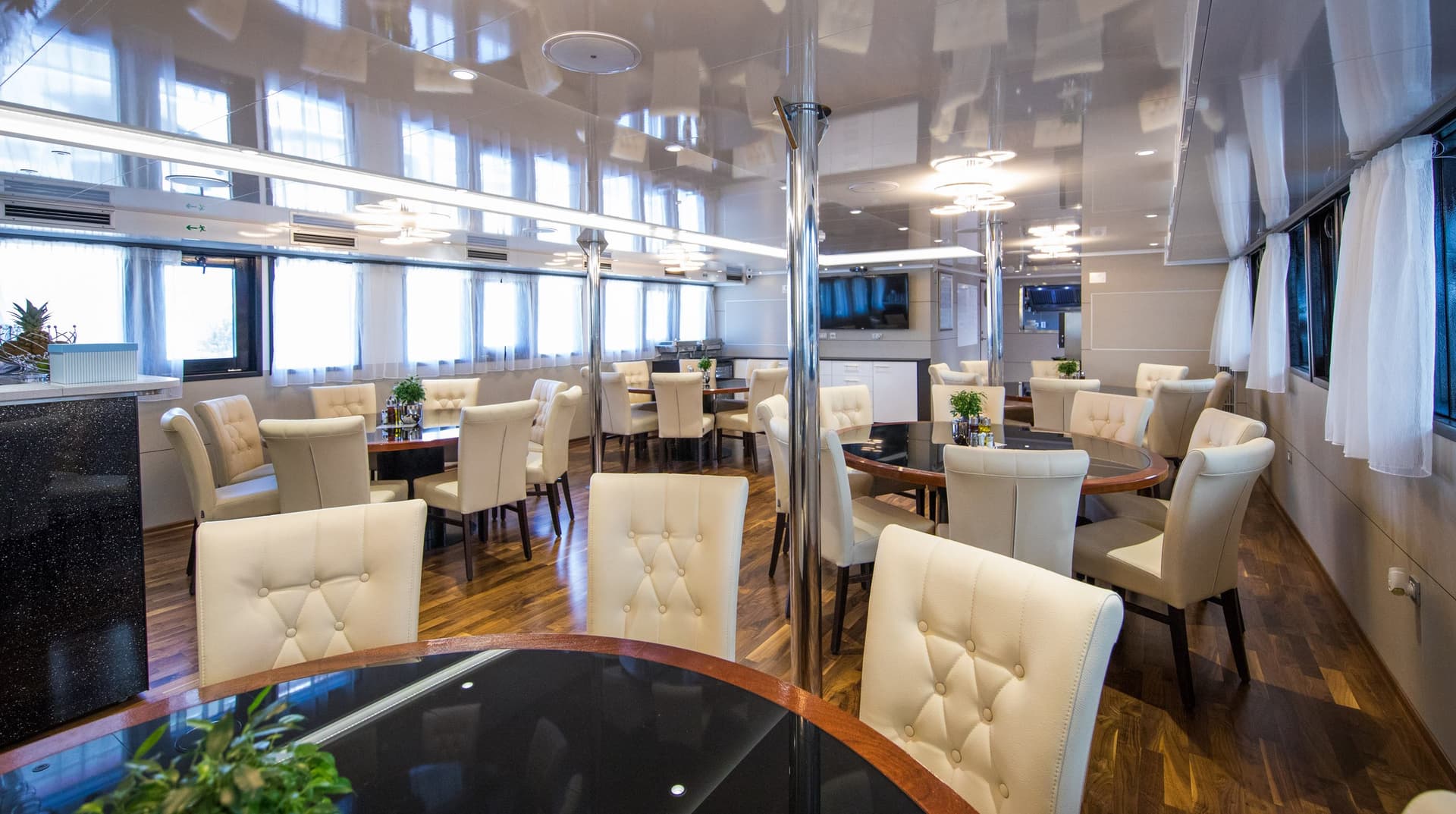 Modern ship restaurant interior with round tables and upholstered chairs