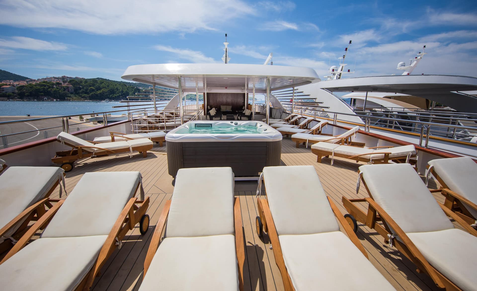 Yacht sun deck with lounge chairs and hot tub on a sunny day