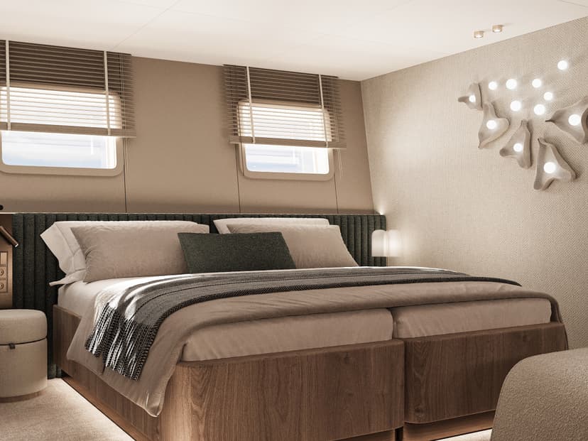 Modern guest cabin interior with large bed and porthole windows