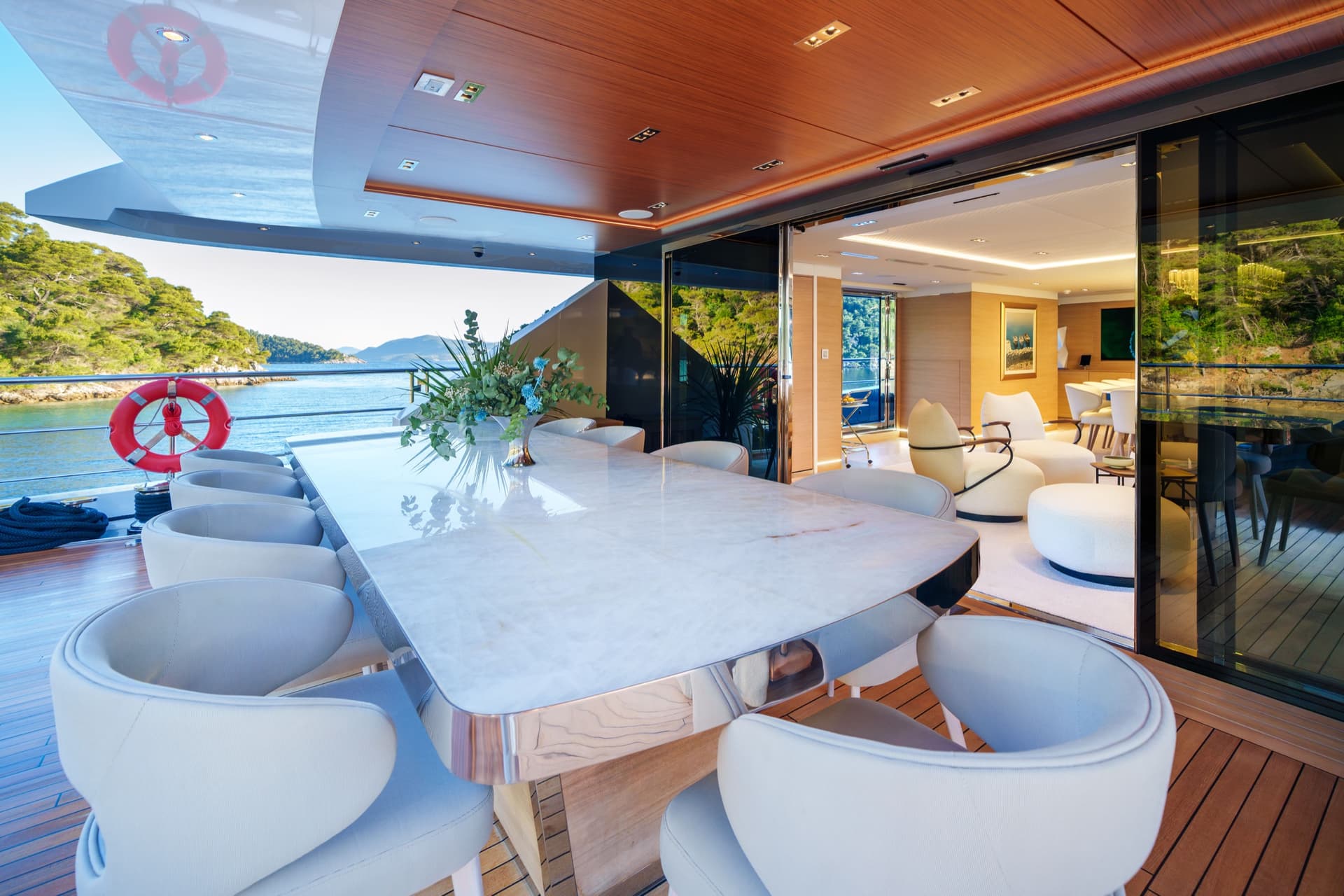 Luxury yacht exterior dining area with marble table and ocean view