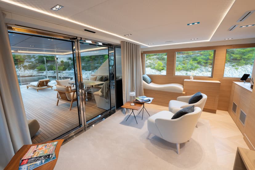 Yacht master deck saloon with seating area and glass sliding doors to aft deck