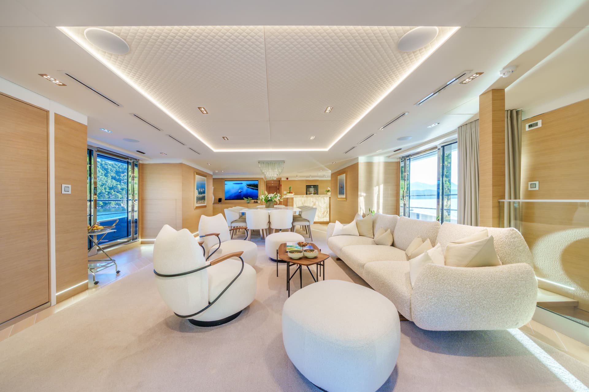 Luxury yacht interior salon with white seating area and dining space