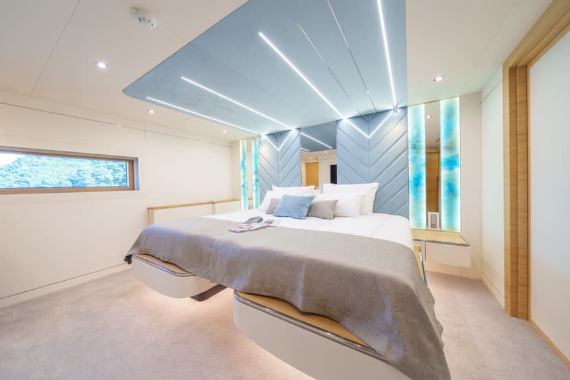 Twin cabin interior with connected bed and blue ceiling lighting on yacht