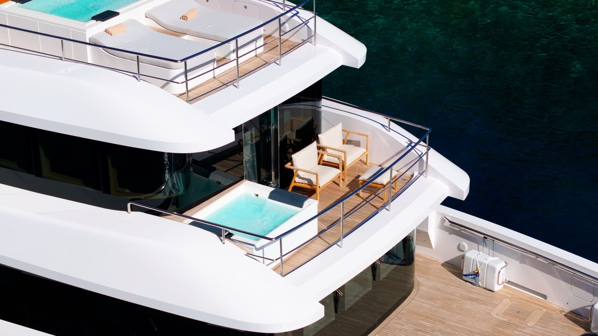 Luxury yacht deck with jacuzzi and lounge chairs overlooking water